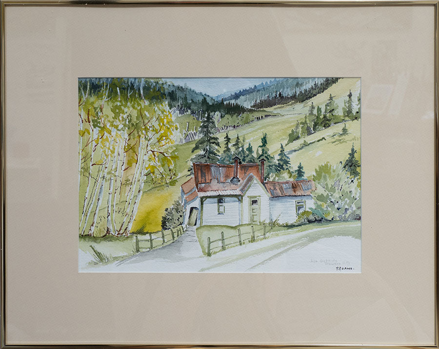 A framed painting of a house on a hillside near Dawson City