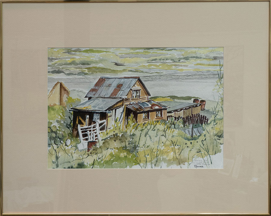 A framed and matted painting of an old house.